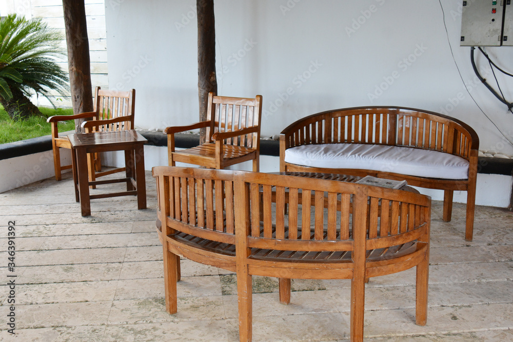 wooden chairs and sofas on the patio