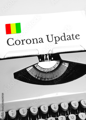 A Typewriter Typing the NEWS of COVID-19 with the Flag of Guinea.