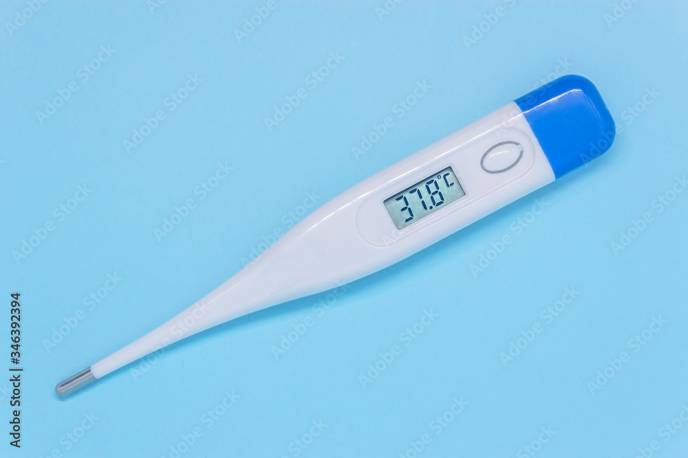 White digital electronic thermometer on a blue background showing high temperature. medical examination concept White digital electronic thermometer on a blue background showing high temperature. medical examination concept
