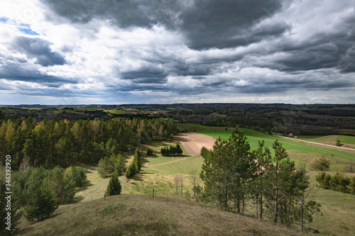 Krajobraz Suwalskiego Parku Narodowego. Widok z Cisowej Góry na lasy, łąki, pola, pagórki w pochmurny dzień