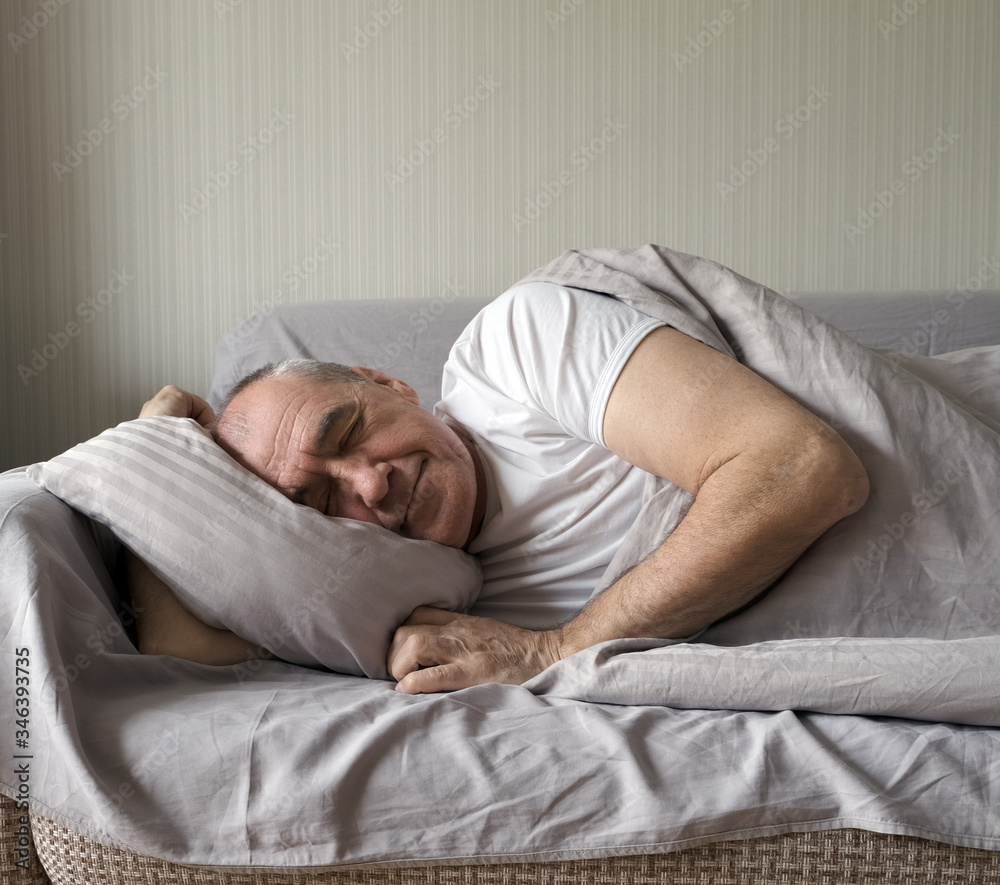 senior man sleeping on a sofa at home in the morning senior man sleeping on a sofa at home in the morning