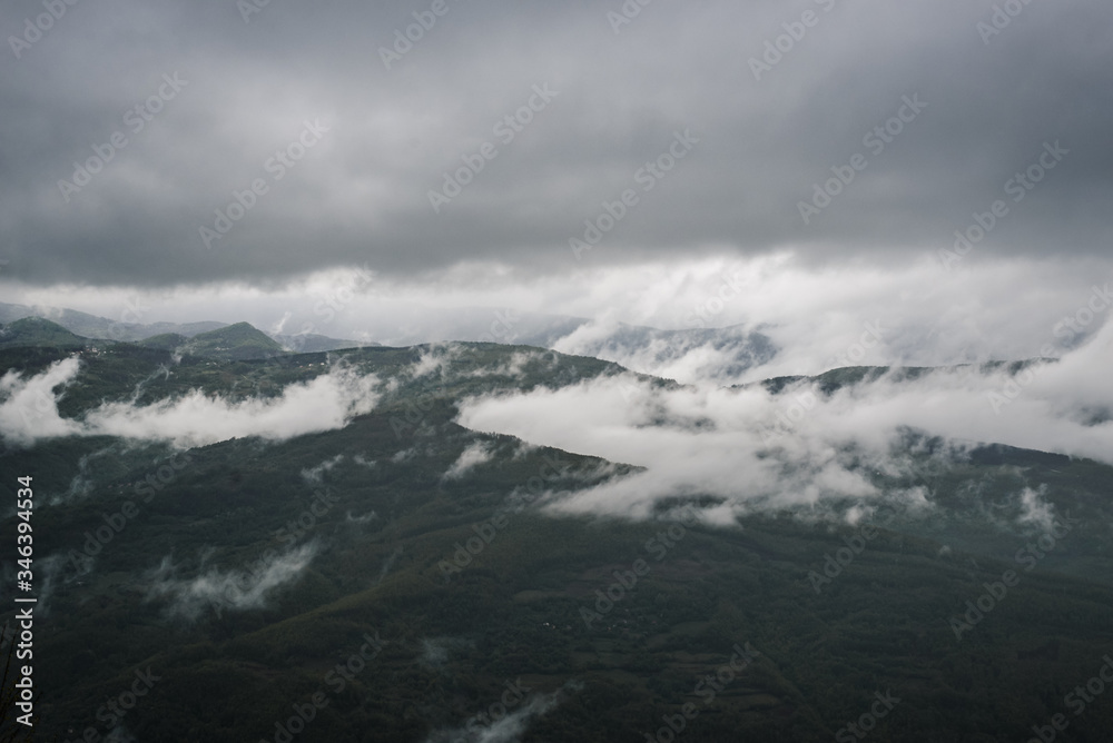 Mountain landscape covered with fog and clouds