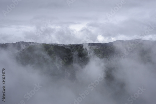 Mountain landscape covered with fog and clouds