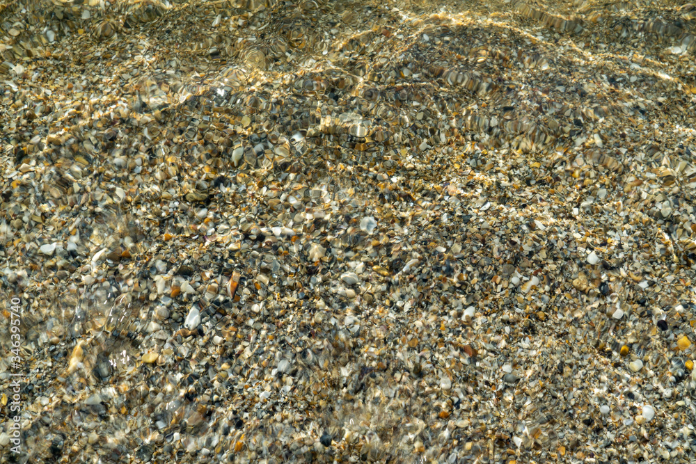 Sea texture of transparent water and pebbles Sea texture of transparent water and pebbles