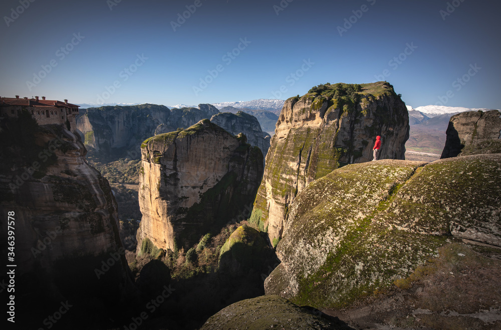 Tourist standing on Meteora rocks over Meteora monastery area Tourist standing on Meteora rocks over Meteora monastery area