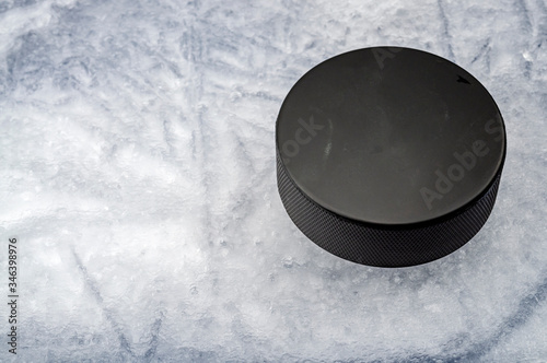 Sports equipment and team winter sport concept with closeup on hokey puck on ice rink with copy space