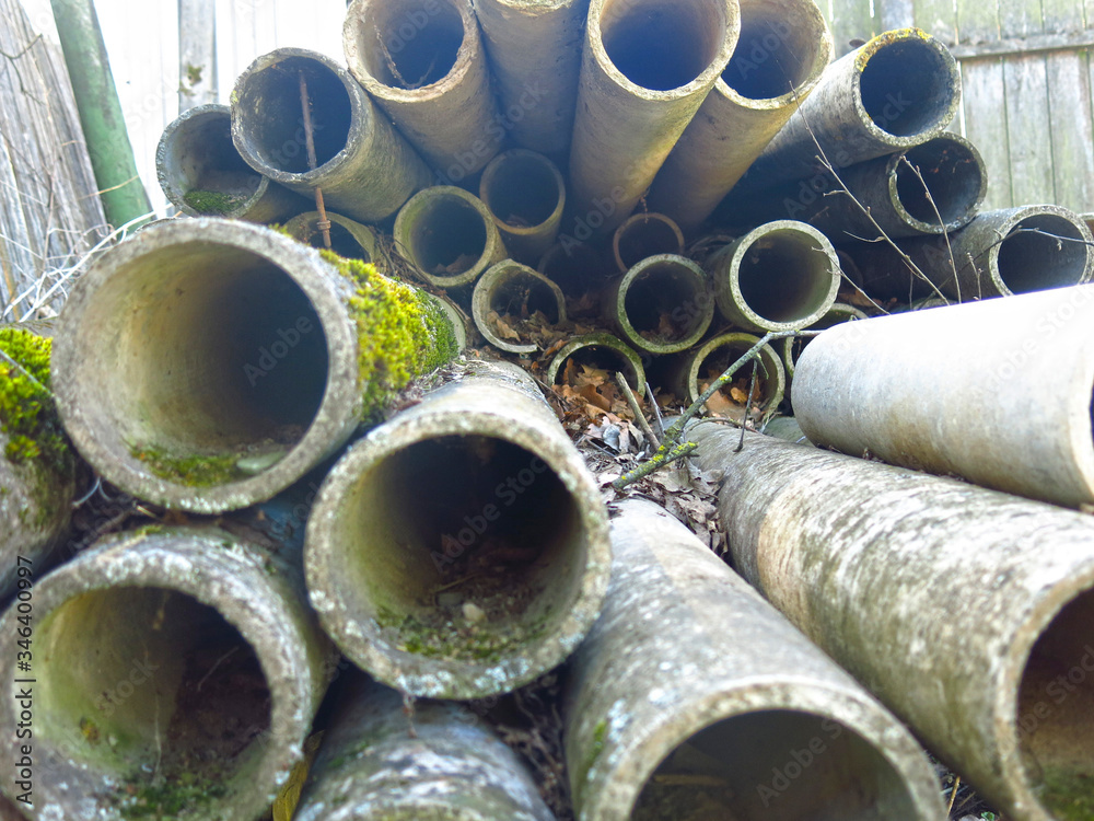 round concrete pipes are covered with moss and lie in a heap round concrete pipes are covered with moss and lie in a heap