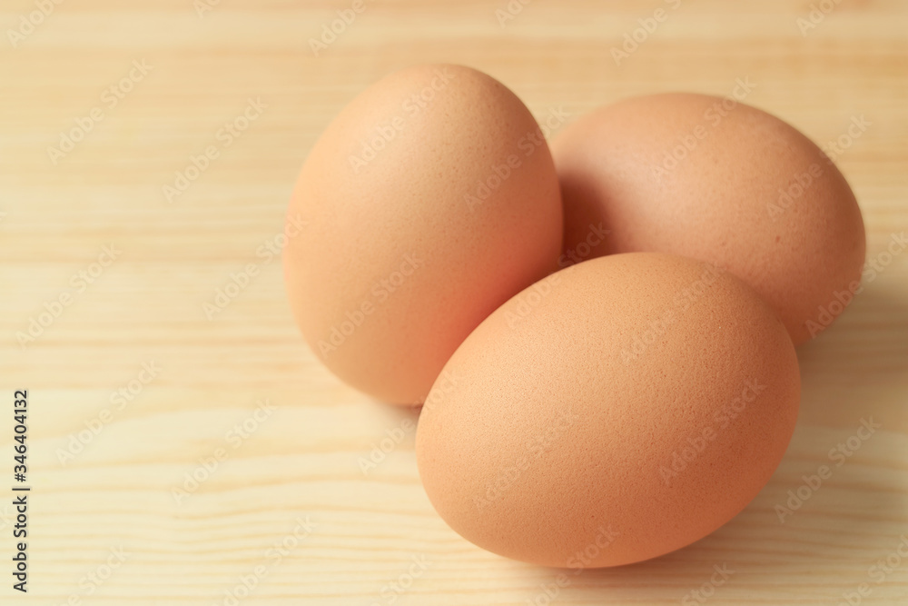 Three of Chicken Eggs Isolated on Wooden Table with Copy Space Three of Chicken Eggs Isolated on Wooden Table with Copy Space