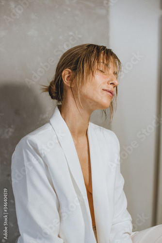 Sensual portrait of a young attractive woman in a white blazer.