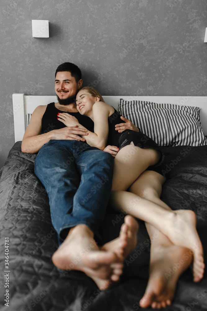 Woman and her man lying on the bed and laughing. Stay home Woman and her man lying on the bed and laughing. Stay home