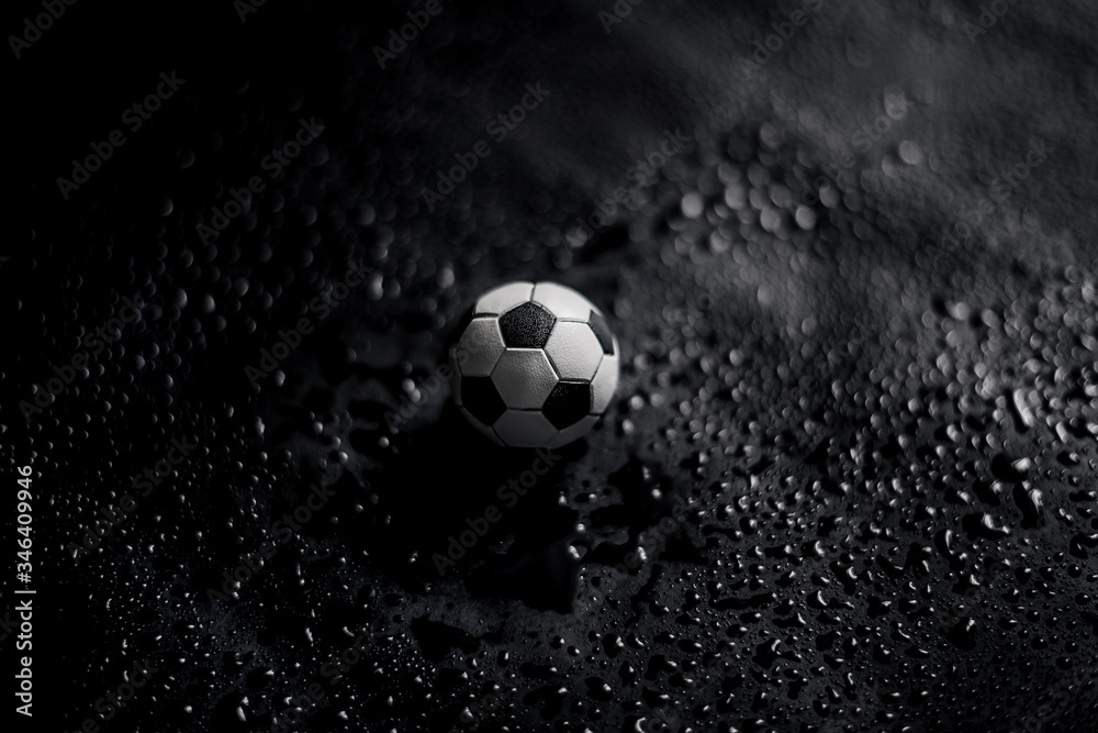 Fototapeta premium Soccer ball on a black background with water drops. 