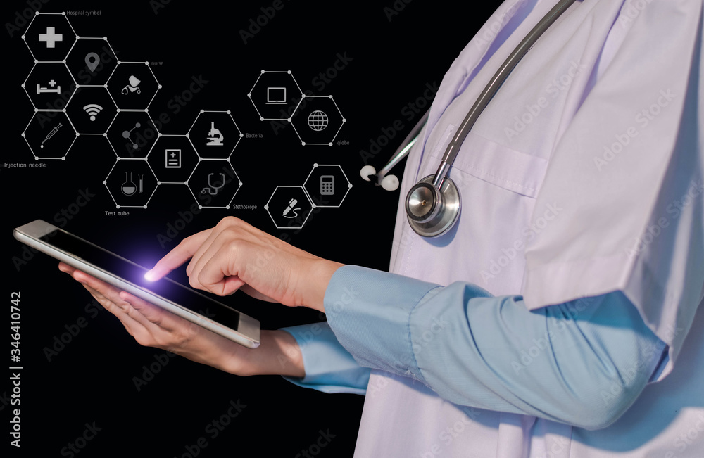 Female doctor stomatologist is working on a tablet and audio player and a digital tablet computer in office. Female doctor stomatologist is working on a tablet and audio player and a digital tablet computer in office.