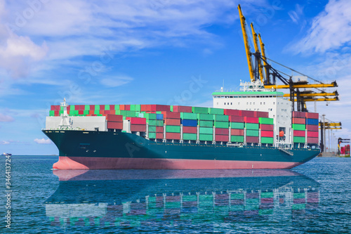 Logistics and Transportation of international Container Cargo ship in the port on blue sky, freight transportation, shipping on tower crane background.