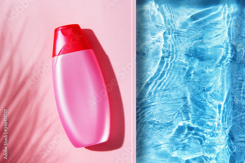 Overhead view of pink shampoo bottle mockup on top of colorful background, next to the swimming pool.