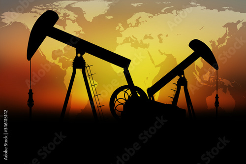 Silhouette of an oil pumps on a sunset background with World map