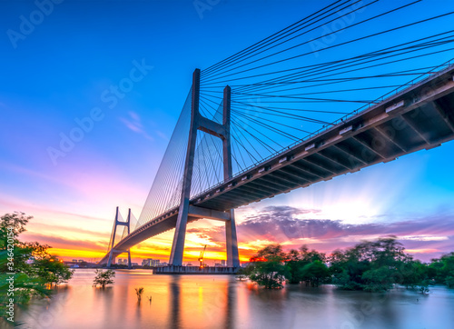 Fototapeta Naklejka Na Ścianę i Meble -  Beautiful sunset landscape at Phu My Bridge. This largest cable-stayed bridge crossing Saigon river connect District 2 and 7 in Ho Chi Minh City, Vietnam