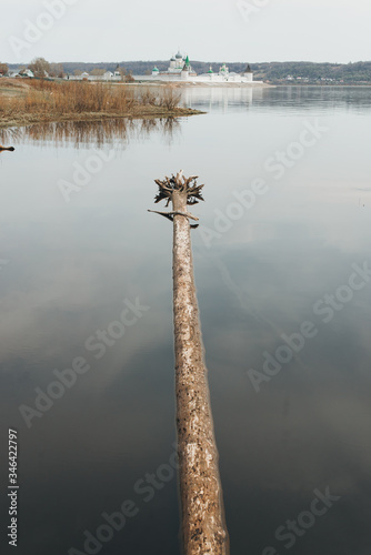 The monastery on the river bank. View of the monastery from the water. Makariev monastery. a sunken log. photo