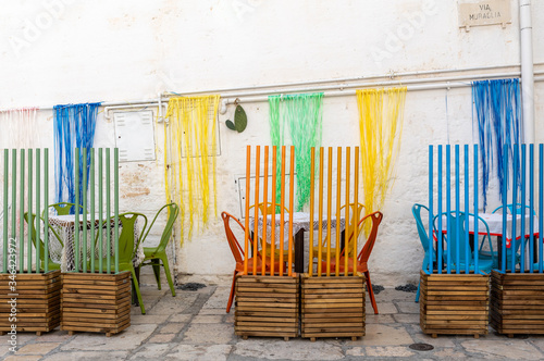 Fototapeta Naklejka Na Ścianę i Meble -  Colorful arrangement of the cafe in one of the side streets of Polignano a Mare. Italy
