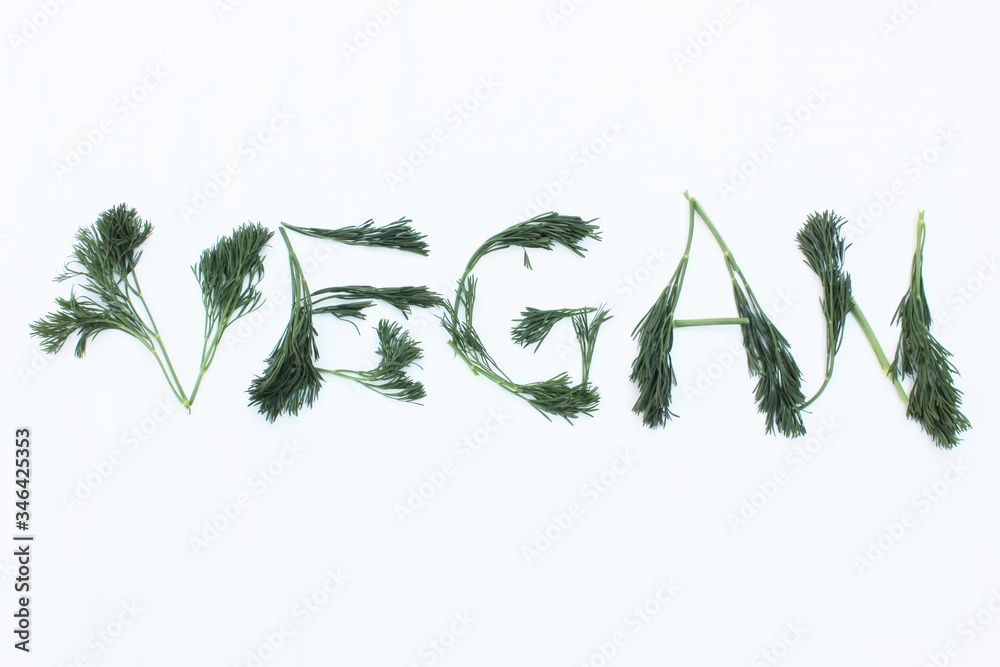 Vegan written from dill and herbs. Concepts for design. The word vegan on a white background, top view. Vegan food concept