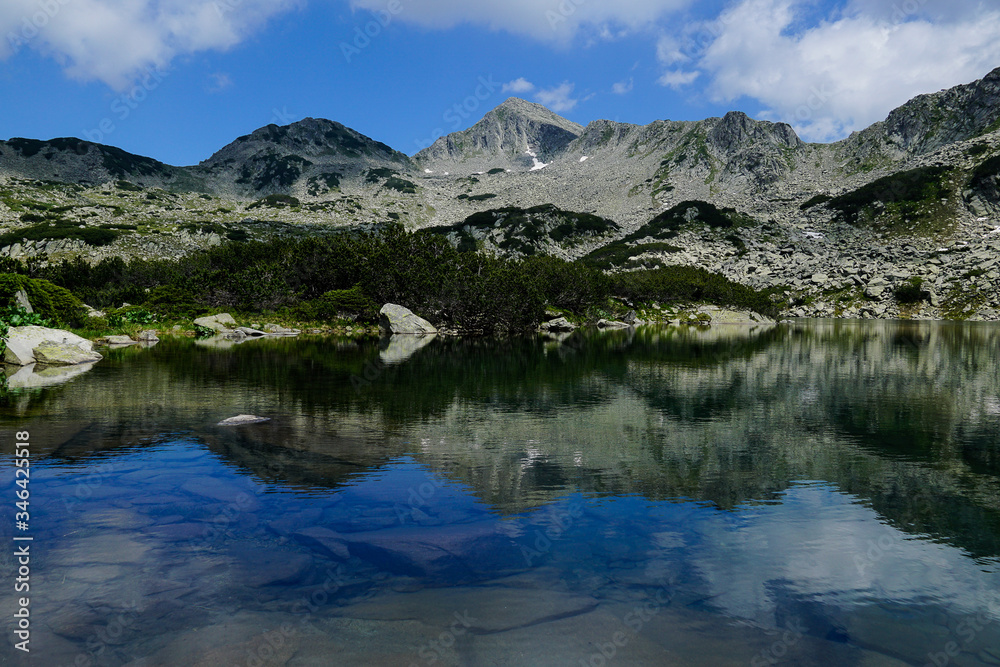 Reflection of rocky peaks in Georgiyski lakes near Sinanitsa in Pirin mountain National park in Bulgaria
