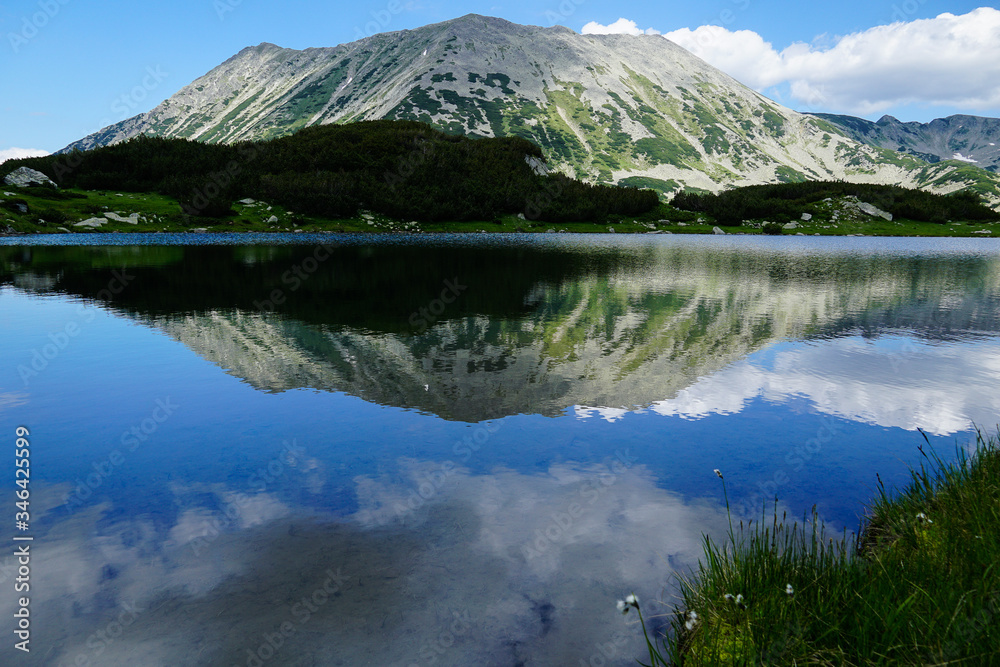 Reflection of rocky Todorka peak in the calm water of Muratovo lakes in Pirin mountain National park in Bulgaria
