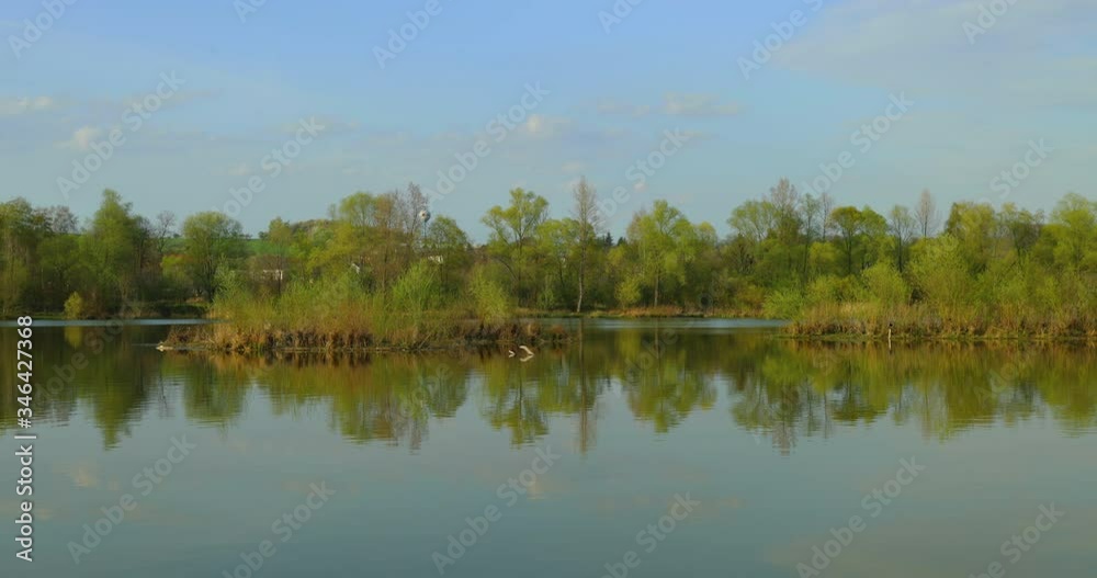 Calm slightly moving the water level of the lake with reflection and a view of the opposite hills and nature Hustopece nad Becvou captured during the spring afternoon 4k 60fps Calm slightly moving the water level of the lake with reflection and a view of the opposite hills and nature Hustopece nad Becvou captured during the spring afternoon 4k 60fps