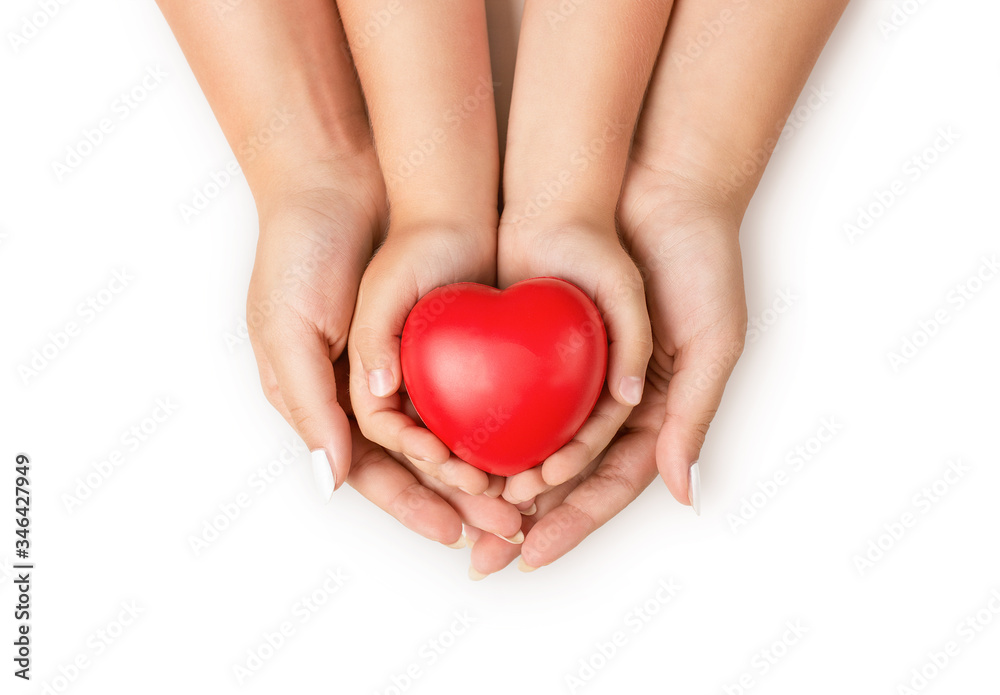 Love, family concept. Close up of mother and children hands holding red rubber heart together isolated on white background Love, family concept. Close up of mother and children hands holding red rubber heart together isolated on white background