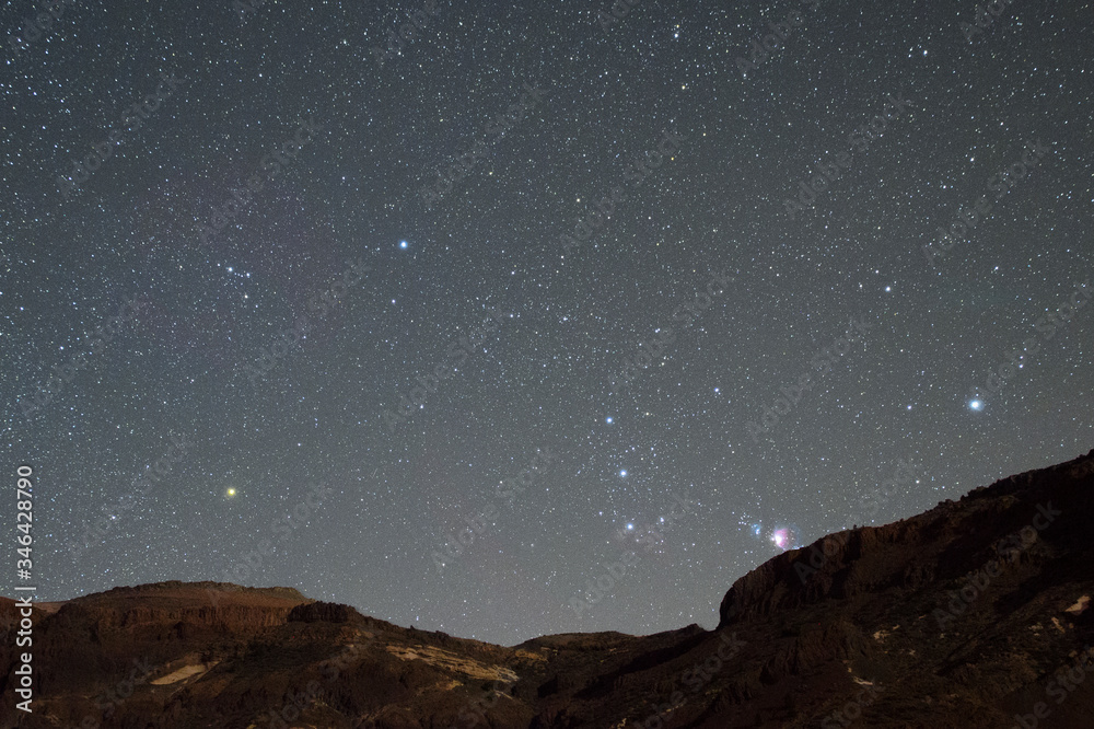 Gwiazdozbiór Oriona wschodzący zza góry na Teneryfie. Wiać mgławicę M42, zarys mgławicy koński łeb, pas oriona, oraz gwiazdę Betelgeza - obrazy, fototapety, plakaty 