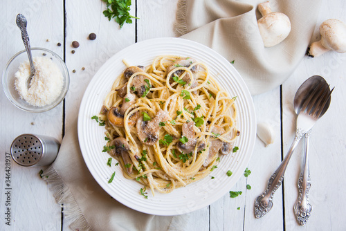 Fototapet Spaghetti pasta with mushrooms, creamy sause and parsley on white