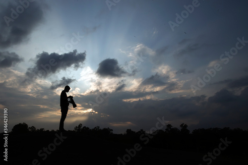 silhouette of a photographer in the sunset © Shakhawat Shaon