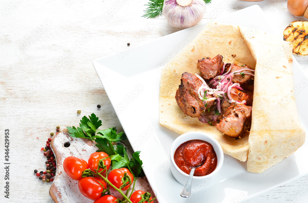 Veal kebab with onions in pita bread. Meat skewers. Top view.
