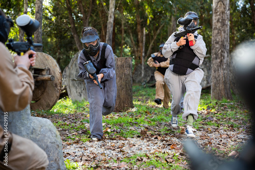 People in full gear playing paintball