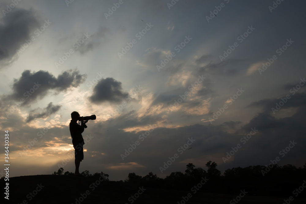 silhouette of a photographer in the sunset