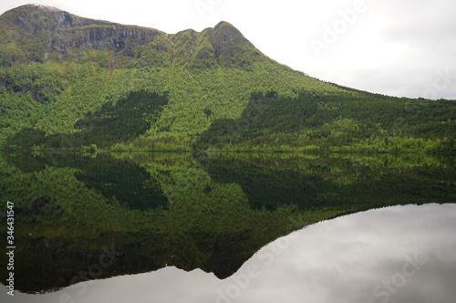 Reflections of forest and mountains in the waters of Vatnevatnet lake in Norway
 photo