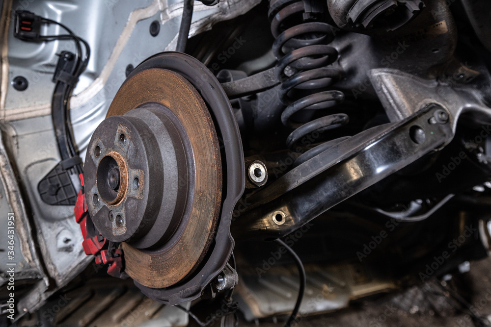 Close-up of a car hub, brake caliper, brake pads, brake disc, wheel bearing prepared for repair. Work at the tire workshop