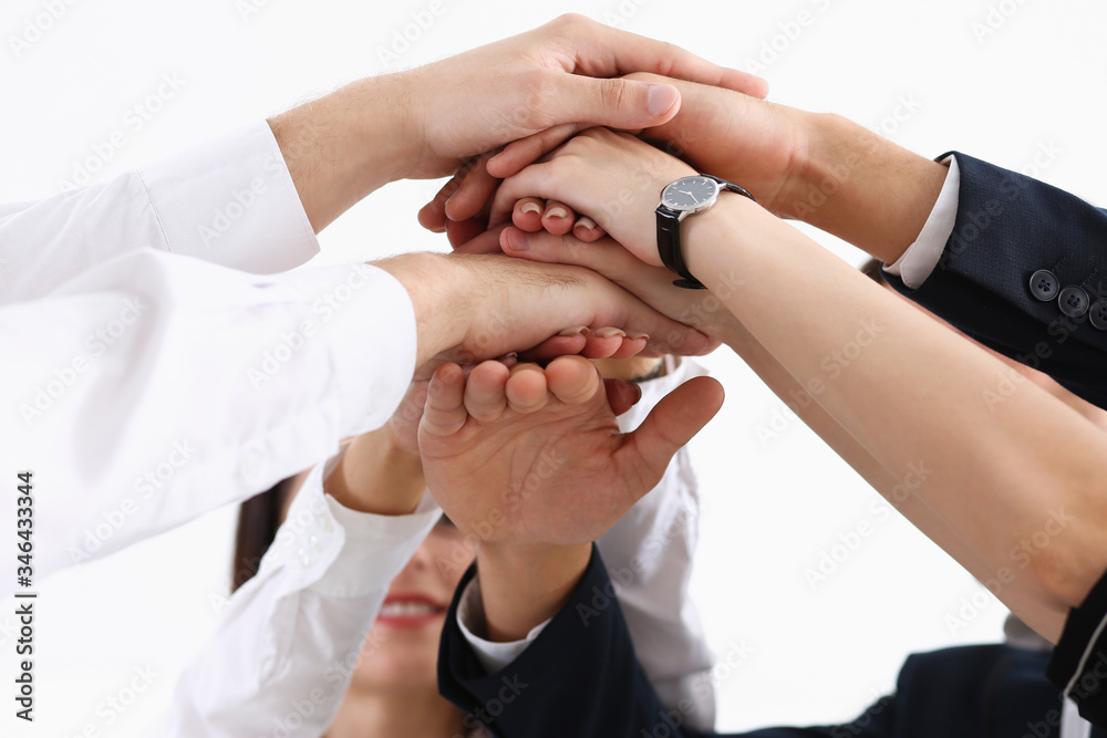 Group of people in suits crossed hands in pile Group of people in suits crossed hands in pile