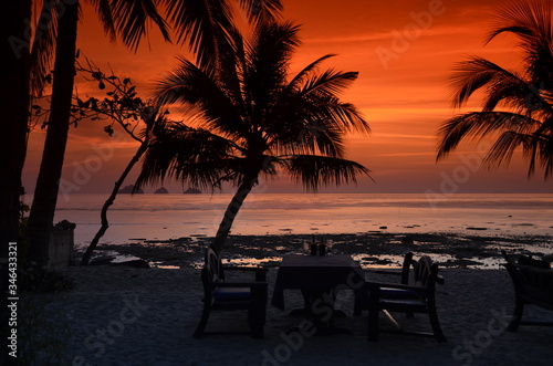 Zachód słońca w romantycznej scenerii na egzotycznej plaży z palmami w Tajlandii