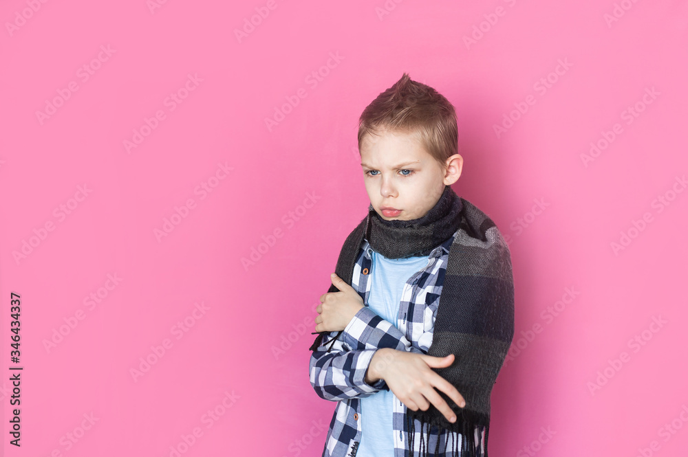 Baby, boy 8-9 years old on pink background sick with coronavirus upset, holds a thermometer Baby, boy 8-9 years old on pink background sick with coronavirus upset, holds a thermometer