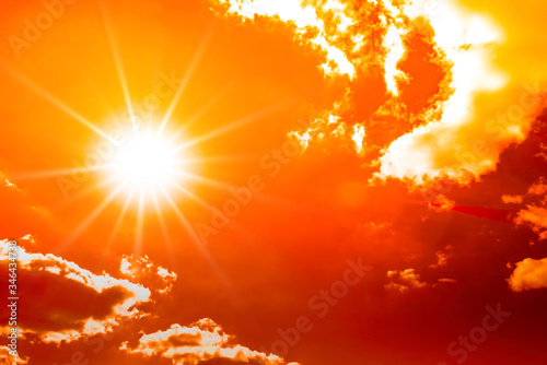 Concept or background for climate change, heat wave or global warming, orange sky with clouds and bright sun