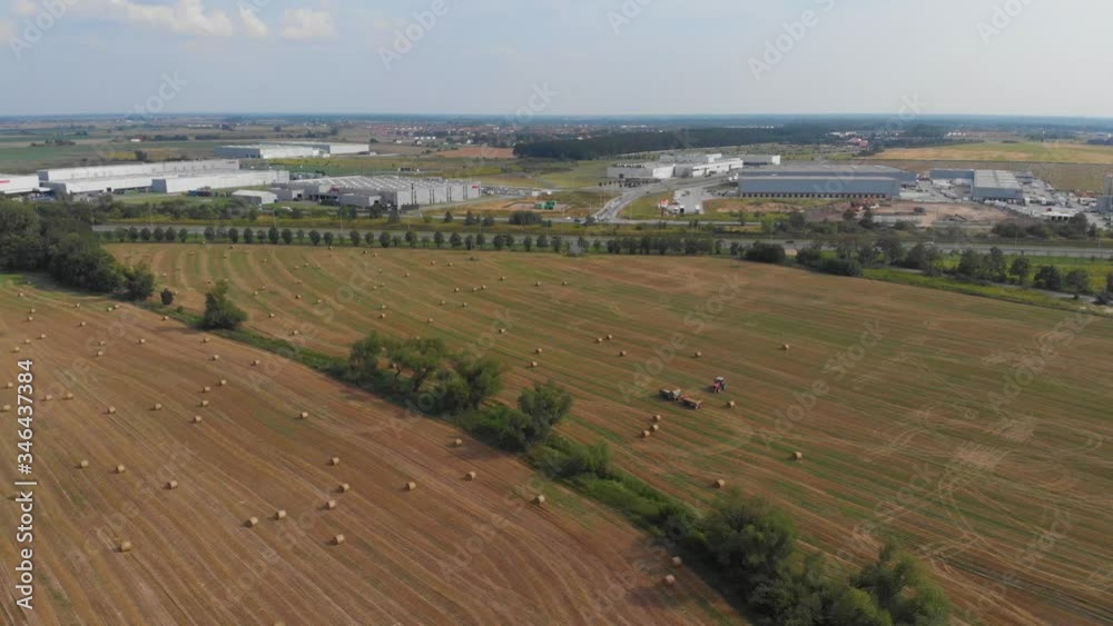 Rural landscape after harvest and adjacent industrial buildings. Aerial pan right to left. Rural landscape after harvest and adjacent industrial buildings. Aerial pan right to left.