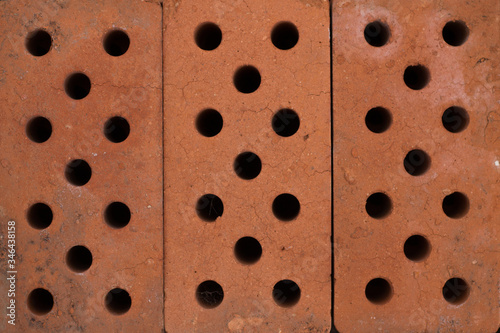 Three brown bricks with many small holes. for background