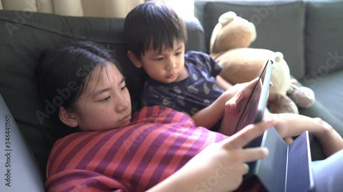 A little boy and sister playing tablet at home