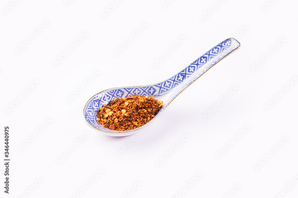 Chili, red pepper flakes and chili powder inside a spoon Chili, red pepper flakes and chili powder inside a spoon