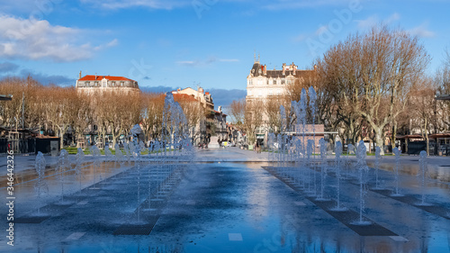 Béziers in France, the Jean-Jaures place, typical facades in the old center, with water jets in a public park 