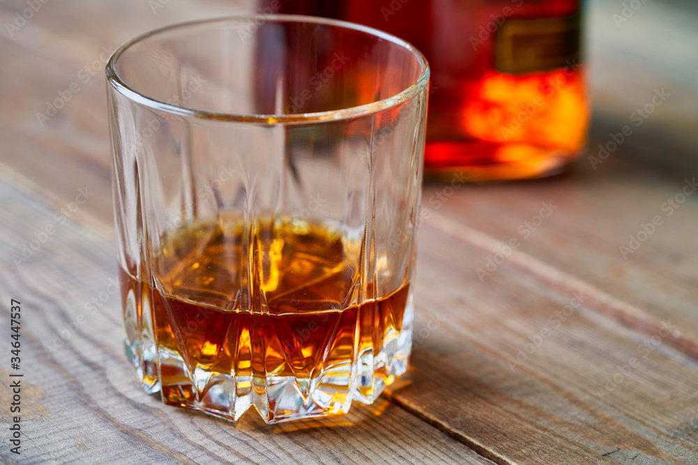 Glass of whiskey on a wooden table