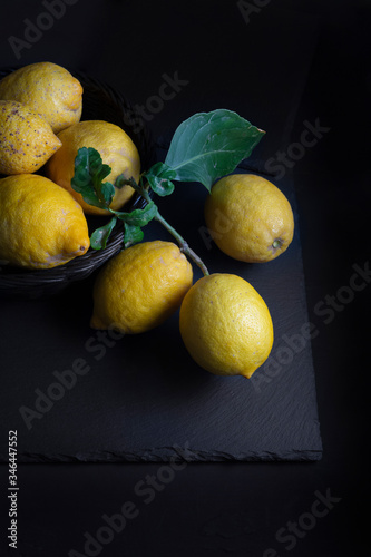 Basket with lemons, on black background