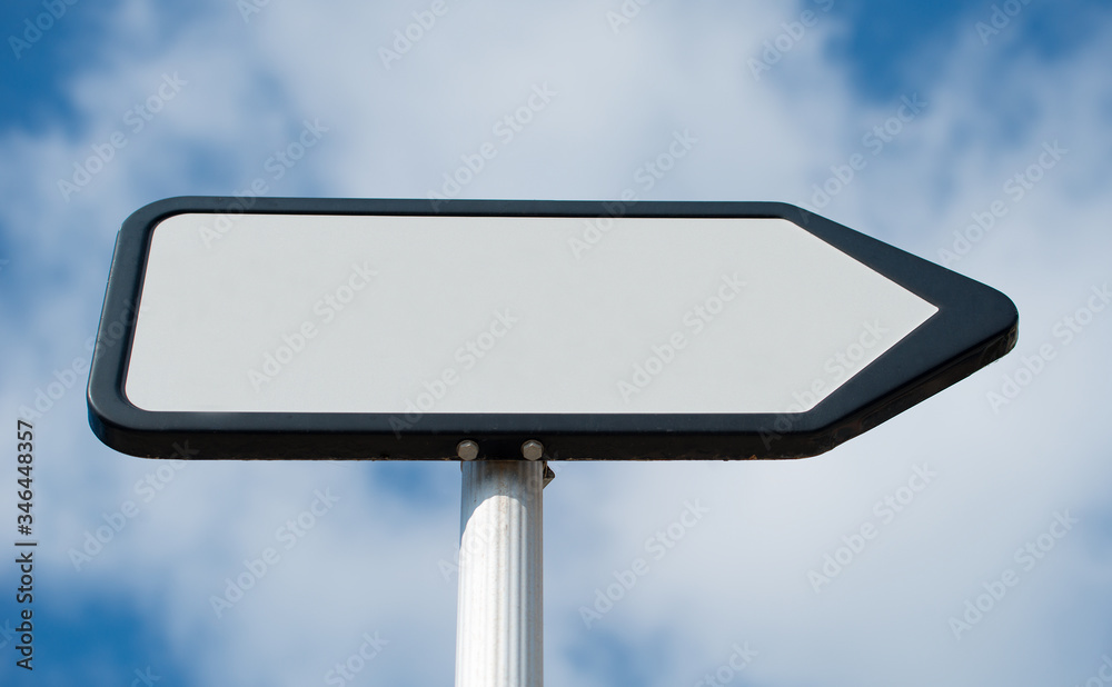 Low angle view of a plain white, blank, pointing the way, information sign post against a blue sky with clouds. Low angle view of a plain white, blank, pointing the way, information sign post against a blue sky with clouds.