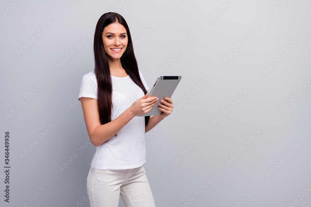 Portrait of her she nice attractive lovely pretty charming cheerful straight-haired girl holding in hands using e-book surfing web isolated over light gray pastel color background Portrait of her she nice attractive lovely pretty charming cheerful straight-haired girl holding in hands using e-book surfing web isolated over light gray pastel color background