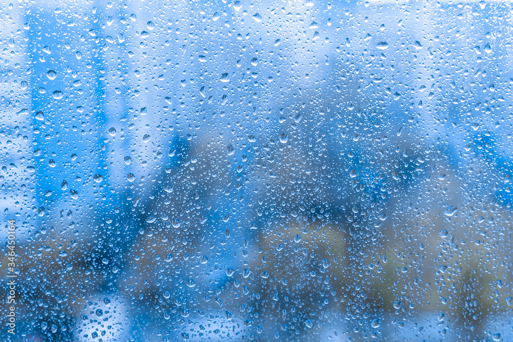 rain drops on the glass window. night rainy window in autumn spring summer. abstract natural view. rainy season. droplets on blue glass window shield. rain drops on the glass window. night rainy window in autumn spring summer. abstract natural view. rainy season. droplets on blue glass window shield.