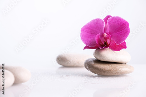 Wellness, relax, massage and wellbeing concept. Spa stones and orchid flower over white background.
